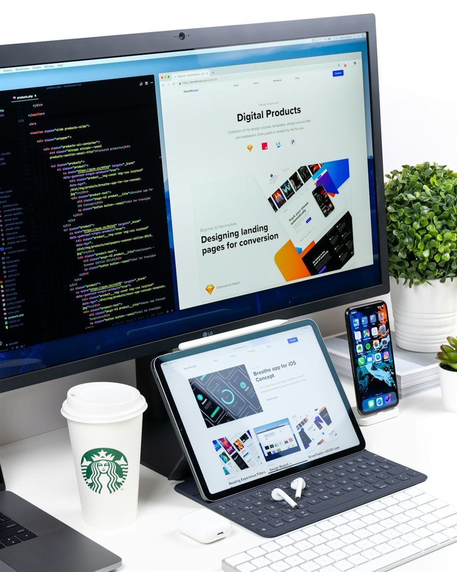Arbeitsplatz mit Monitor, Tablet und Smartphone, die eine Website zeigen
